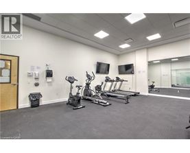 A gym with treadmills, exercise bikes, and a television.