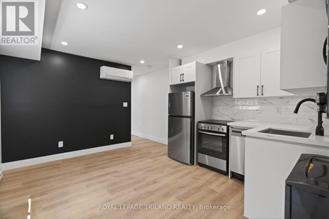 A modern kitchen with white cabinets and stainless steel appliances.