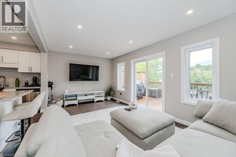 A modern living room with a white sofa set and a television.