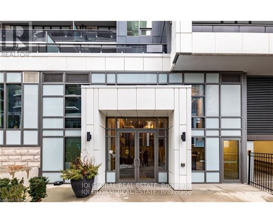 A modern building with a glass entrance and a sign that reads "IQI GLOBAL REAL ESTATE BROKERAGE".