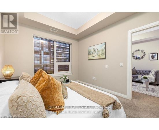 A bedroom with a large bed and a painting on the wall.
