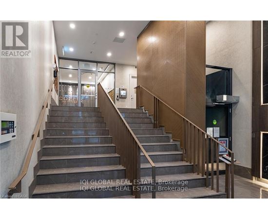 A staircase with a metal railing and a glass door at the top.