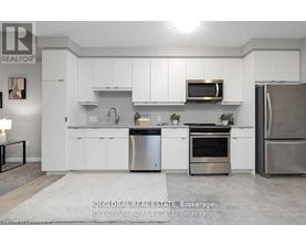 A modern kitchen with white cabinets and stainless steel appliances.
