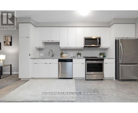A modern kitchen with white cabinets and stainless steel appliances.