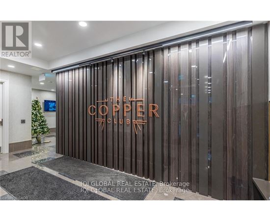 The Corner Club is a modern and sleek establishment with a dark wood panelled wall and a glass door.