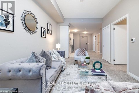 A well-lit, modern living room with a grey sofa and a glass coffee table.