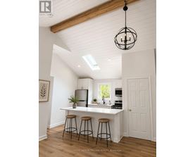 A kitchen with white walls and wooden floors.