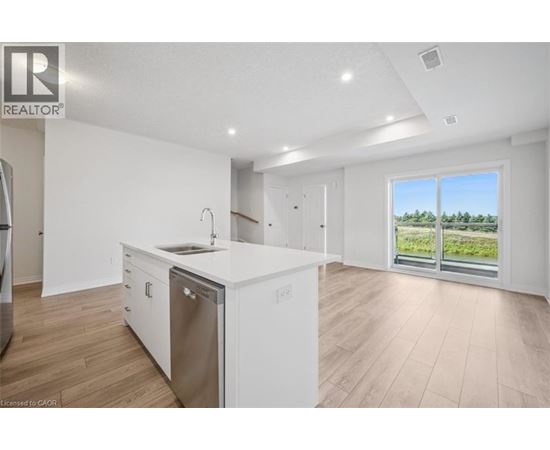 A modern kitchen with white cabinets and a large window.