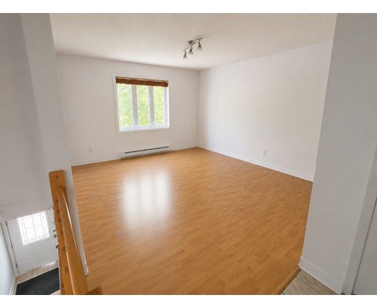 A room with wooden flooring and a window.
