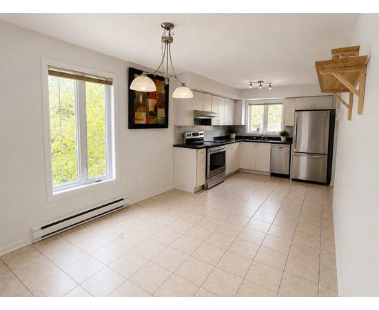 A kitchen with white cabinets and a tiled floor.