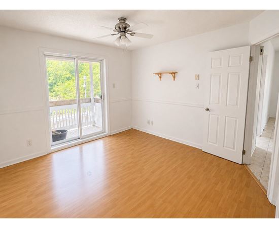 A room with a sliding glass door leading to a balcony.