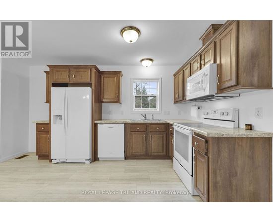 A kitchen with wooden cabinets and white appliances.