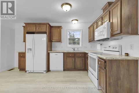 A kitchen with wooden cabinets and white appliances.