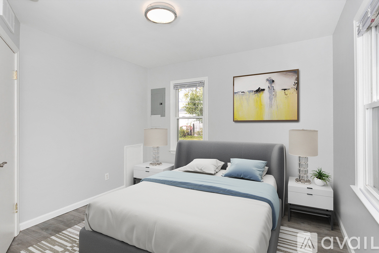 A bedroom with a bed, nightstand, and a painting on the wall.