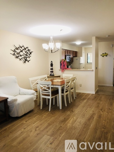 A dining room with a white couch and a wooden table.