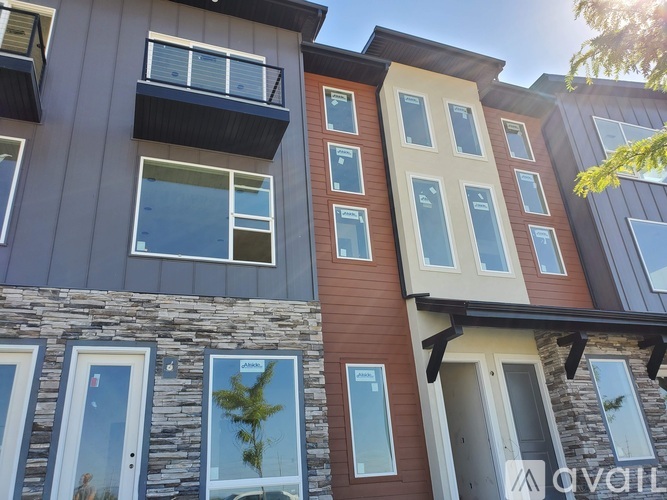 A modern apartment building with a mix of stone and siding exteriors.