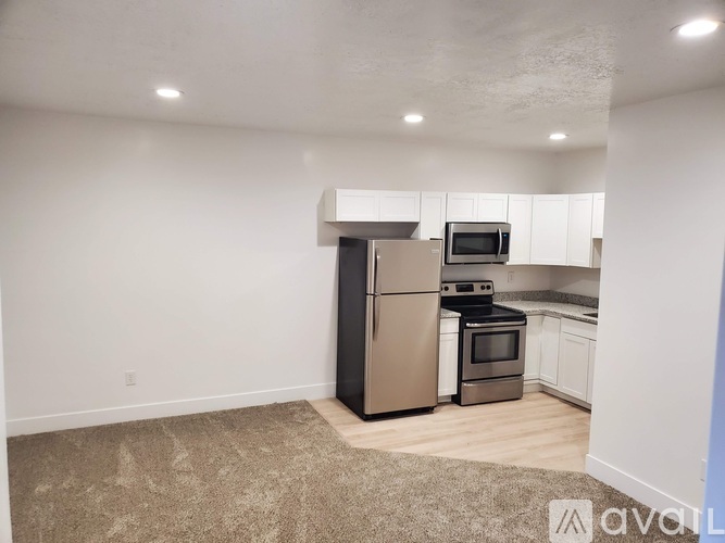 A kitchen with a refrigerator, microwave, oven, and stove.