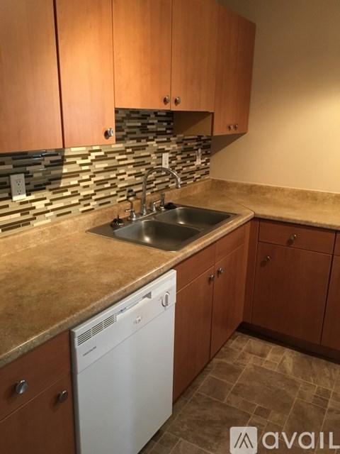 A kitchen with wooden cabinets and a stone backsplash.