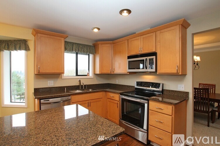 A kitchen with wooden cabinets and granite countertops.