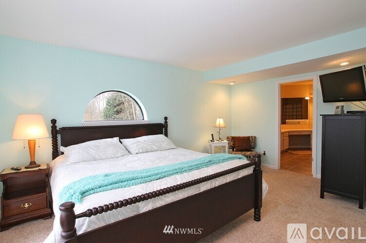 A bedroom with a bed, nightstand, and lamp.