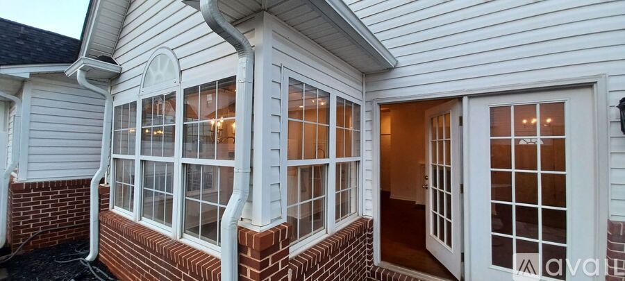 A house with a white exterior and a large window with a view of the sky.