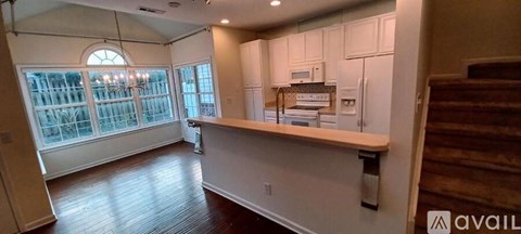 A kitchen with white cabinets and a window.
