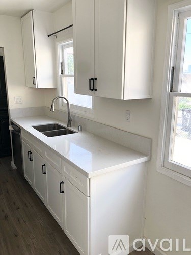 A kitchen with white cabinets and a sink.