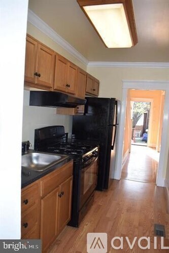 A kitchen with wooden cabinets and black appliances.