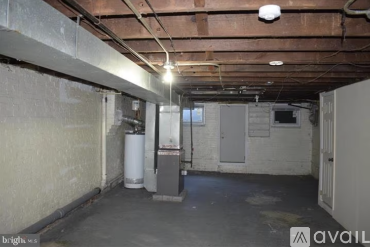 A spacious basement with a concrete floor and walls, a water heater, and a furnace.