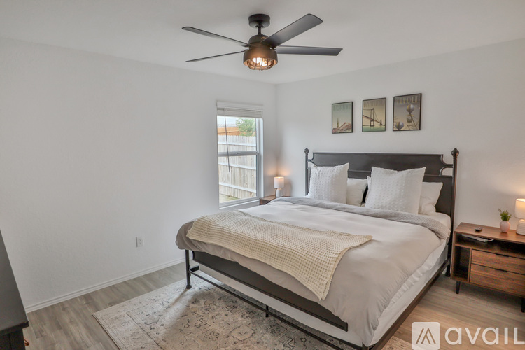 A bedroom with a large bed and a ceiling fan.