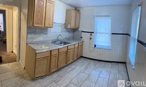 A kitchen with wooden cabinets and a marble countertop.