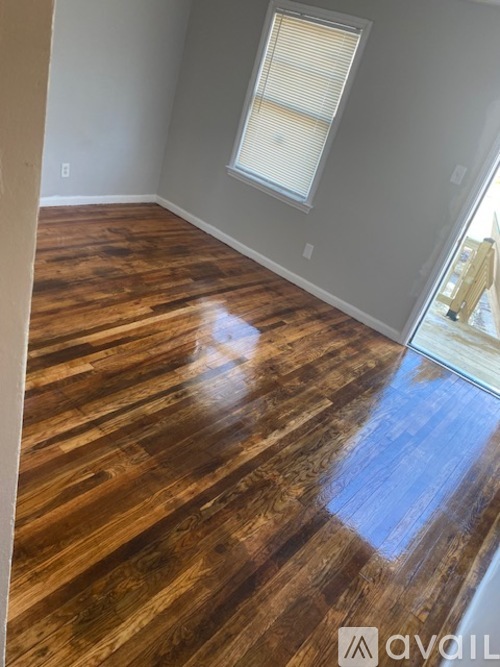 A room with wooden flooring and a window.