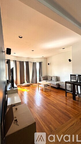 A spacious room with wooden floors and blue walls.