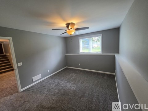 A room with a ceiling fan and a window.