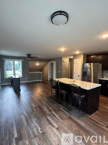 A kitchen with a bar area and a ceiling fan.