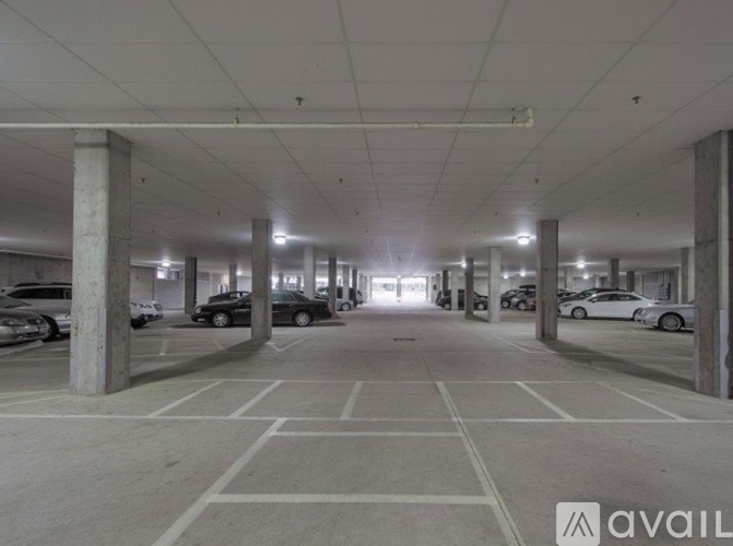 A spacious parking garage with multiple cars parked.