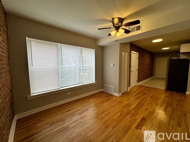 A room with wooden floors and a ceiling fan.