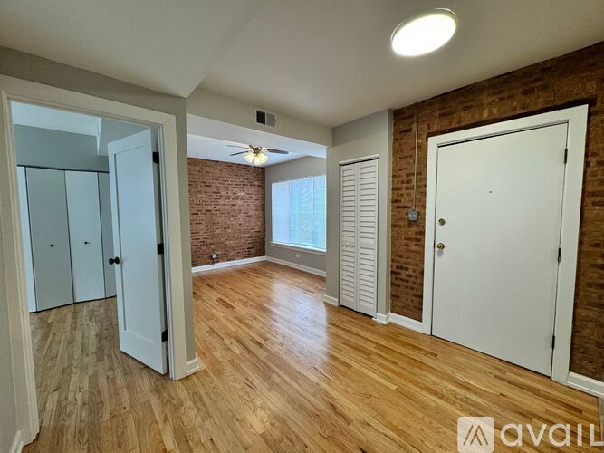 A room with wooden floors and a brick wall.