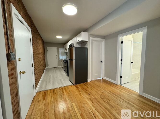 A long hallway with a wooden floor and white walls.