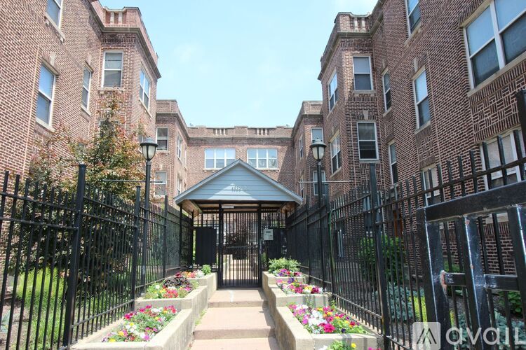 A brick building with a black fence and a gazebo in the center.