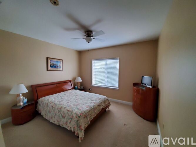 A bedroom with a bed, nightstand, and a ceiling fan.