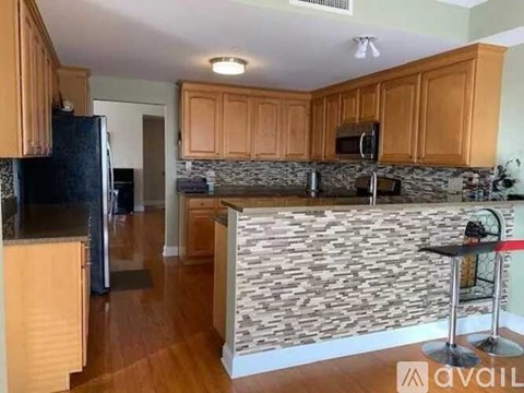 A kitchen with wooden cabinets and a stone backsplash.