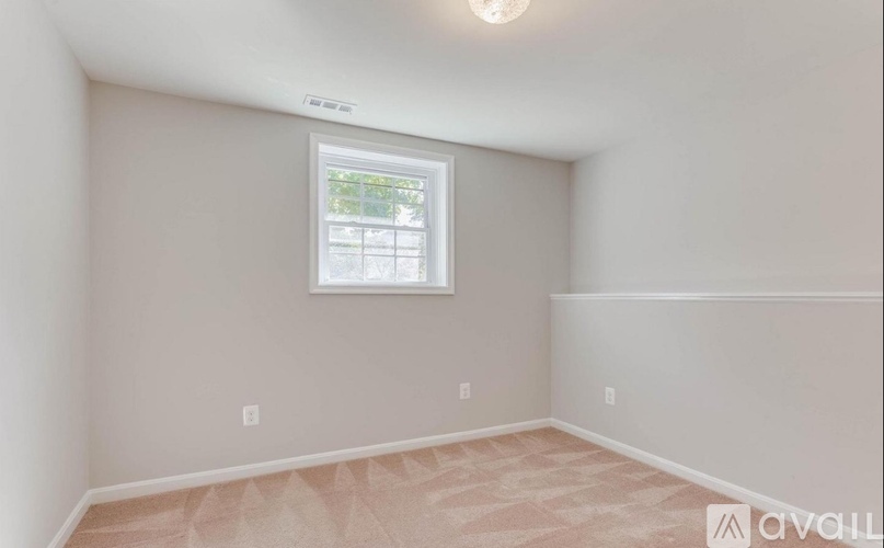 A room with a window and a light on the ceiling.