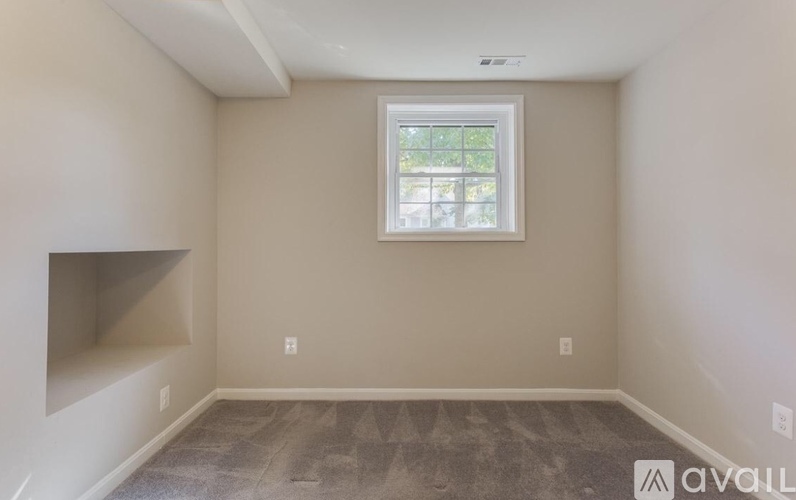 A room with a window and a fireplace on the left side.