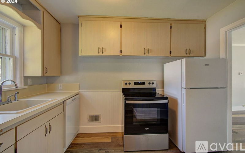 A kitchen with wooden cabinets and a white refrigerator.
