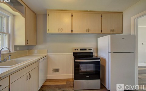 A kitchen with wooden cabinets and a white refrigerator.