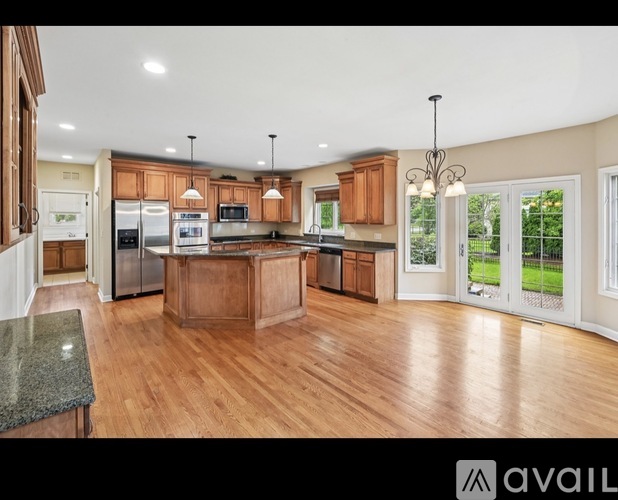 A kitchen with wooden cabinets and a granite countertop.