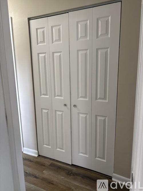 A white double door with a silver handle.