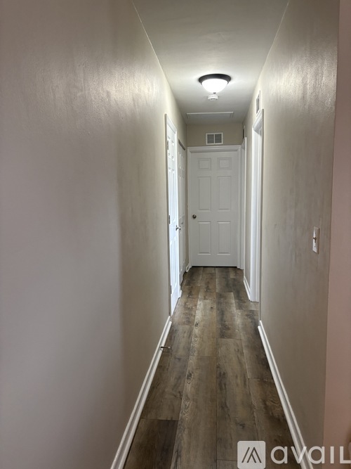 A long hallway with a white door at the end.