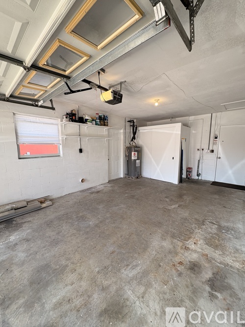 A large, empty room with a concrete floor and white walls.